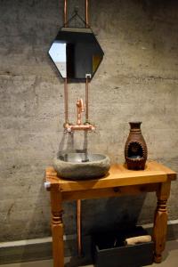 a sink on a wooden table with a lamp and a vase at The Hans Apartment - cosy and special in Klaksvík
