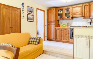uma sala de estar com um sofá amarelo numa cozinha em 2 Bedroom Cozy Apartment In Grotte Di Castro em Grotte di Castro