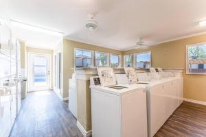 a laundry room with a row of washers and dryers at Central 1BR King Bed Suites, Close to Downtown & Domain in Austin