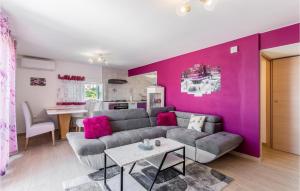 uma sala de estar com um sofá e uma parede roxa em Awesome Apartment In Kostrena With Wifi em Kostrena