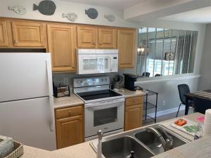 a kitchen with a white refrigerator and a stove top oven at 2504 Commons II in Calabash