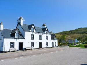 ein weißes Gebäude am Straßenrand in der Unterkunft Seaview-Barsloisnach Cottage in Kilmartin