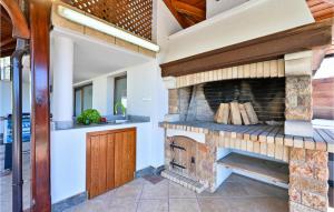 an outdoor kitchen with a stone fireplace in a house at Beautiful Home In Ljubescica With Wifi in Ljubešćica