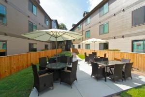 a patio with tables and chairs and an umbrella at Extended Stay Apartments Next to Downtown in Austin