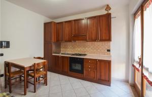 里卡迪的住宿－Awesome Apartment In Ricadi With Wifi，厨房配有木制橱柜、桌子和桌椅