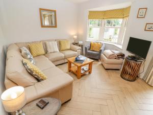 a living room with a couch and a tv at Church View in Bourton on the Water