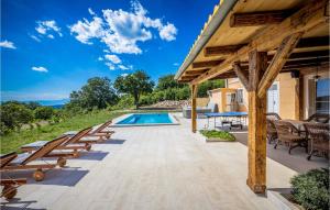an outdoor patio with chairs and a swimming pool at Cozy Home In Bribir With Jacuzzi in Bribir
