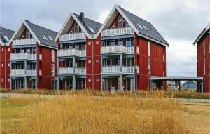 a row of red apartment buildings in a field at Stunning Apartment In Rechlin With Lake View in Zielow