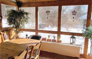 einen Tisch und Stühle in einem Zimmer mit Fenster in der Unterkunft Ferienhaus Bahnhaus K in Regenhütte