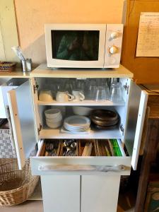 a microwave oven sitting on top of a refrigerator at 自然の中の古民家ゲストハウスちゃいはな庵 Organic county style classic house Chaihana an in Lake Toya