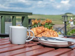 a table with a cup of coffee and a plate of food at 2 Rockmount in Salcombe