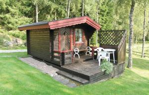 Cabaña de madera con mesa y sillas en el césped en Nice Home In Svenljunga With House Sea View, en Svenljunga