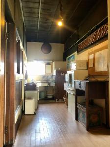 a large kitchen with many appliances in a room at 自然の中の古民家ゲストハウスちゃいはな庵 Organic county style classic house Chaihana an in Lake Toya