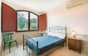a bedroom with a bed and a chair and a window at Rustico Gli Oleandri in Orgosolo