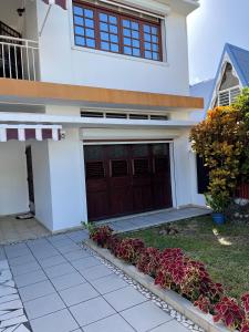 a house with a garage and flowers in front of it at CD House in Fort-de-France