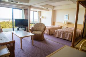 宮崎市にあるラグゼ 一ツ葉 / コテージ・ヒムカのベッド2台とテレビが備わるホテルルームです。