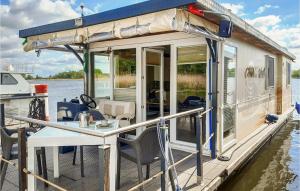 a house boat with a table on the dock at Gorgeous Ship In Havelsee With House Sea View in Kützkow