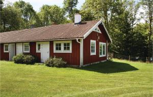 een rood-wit huis met een grasveld bij Cozy Home In Karlskrona With House Sea View in Fröbbestorp