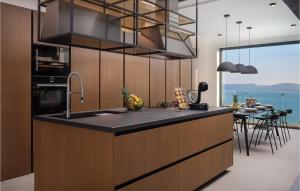 a kitchen with a counter with a sink and a table at Stunning Home In Omis With Kitchen in Omiš
