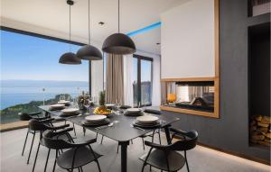 a dining room with a table and chairs and a large window at Stunning Home In Omis With Kitchen in Omiš