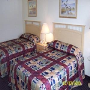 una camera d'albergo con due letti e una lampada di Ameristay Inn & Suites a Waverly