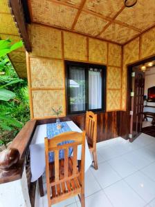 uma sala de jantar com mesa e cadeiras numa casa em Hof Gorei Beach Resort Davao em Samal