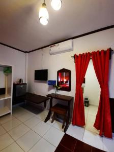 sala de estar con mesa y cortinas rojas en Hof Gorei Beach Resort Davao en Samal