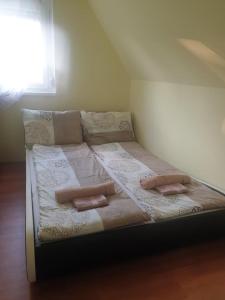 a large bed with pillows on it in a room at Sinka Vendégház in Békésszentandrás