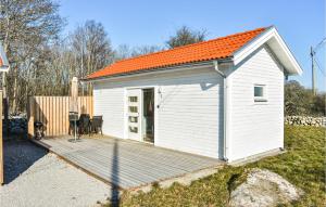 ein kleiner weißer Schuppen mit orangefarbenem Dach in der Unterkunft Stunning Home In Hassl With Kitchen in Hasslö