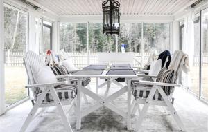 4 Bedroom Nice Home In Karlstad في كارلشتاد: غرفة طعام بيضاء مع طاولة بيضاء وكراسي