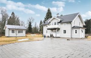 a white house with a driveway in front of it at 4 Bedroom Nice Home In Karlstad in Karlstad