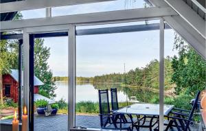 a screened porch with a table and a view of a lake at Stunning Home In Figeholm With 2 Bedrooms And Wifi in Kråkemåla