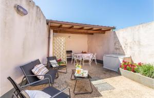 a patio with chairs and a table and a kitchen at 3 Bedroom Beautiful Home In Milis in Milis