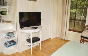 sala de estar con mesa y TV en Nice Home In Blsta With 1 Bedrooms, Sauna And Internet, en Bålsta