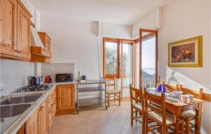 a kitchen with a sink and a table with chairs at Nice Home In Rapallo With Kitchen in Rapallo