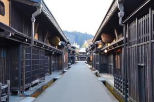 an empty alley between two buildings with fences at 桜丸 Sakuramaru in Takayama
