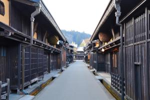 eine leere Gasse zwischen zwei Gebäuden mit Zäunen in der Unterkunft 桜丸 Sakuramaru in Takayama