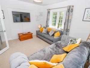 a living room with a gray couch and yellow pillows at Galatea in Bembridge