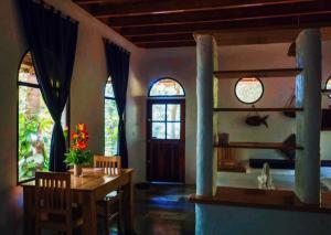 a dining room with a table and chairs and windows at Kim's Garden in Anda
