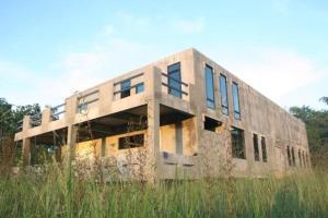 un edificio seduto in mezzo a un campo di Starry Night hostel a Ban Mae Chong