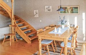 ein Esszimmer mit einem Holztisch und einer Treppe in der Unterkunft 3 Bedroom Cozy Home In Lngaryd in Långaryd