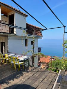 een houten terras met een tafel en stoelen op een huis bij Sonce Guest House in Ohrid