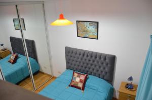 - un salon avec un canapé bleu et un miroir dans l'établissement Apartamento Viajero, à Buenos Aires