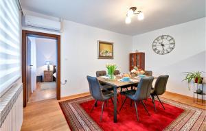 jadalnia ze stołem i krzesłami na czerwonym dywanie w obiekcie 2 Bedroom Beautiful Home In Trnovec w mieście Trnovec