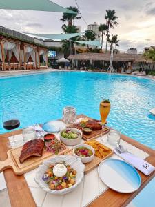 a table with food and drinks next to a swimming pool at Thien Ha Hotel & Apartment in Ho Chi Minh City