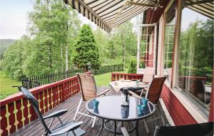 a patio with two tables and chairs on a deck at Gorgeous Home In Kvinlog With Kitchen in Kvinlog