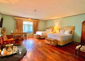 una camera d'albergo con due letti e un soggiorno di Hotel Portal del Angel a Tegucigalpa