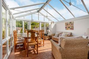 a conservatory with a glass roof with a table and chairs at 21 Church Street in Llangollen