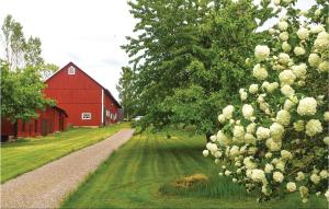 un granero rojo y un camino junto a un árbol en Amazing Home In Vimmerby With House Sea View, en Vimmerby
