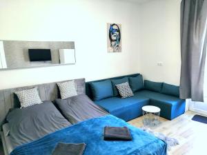 a living room with a blue couch and a blue blanket at Bereg Szíve Apartman in Vásárosnamény